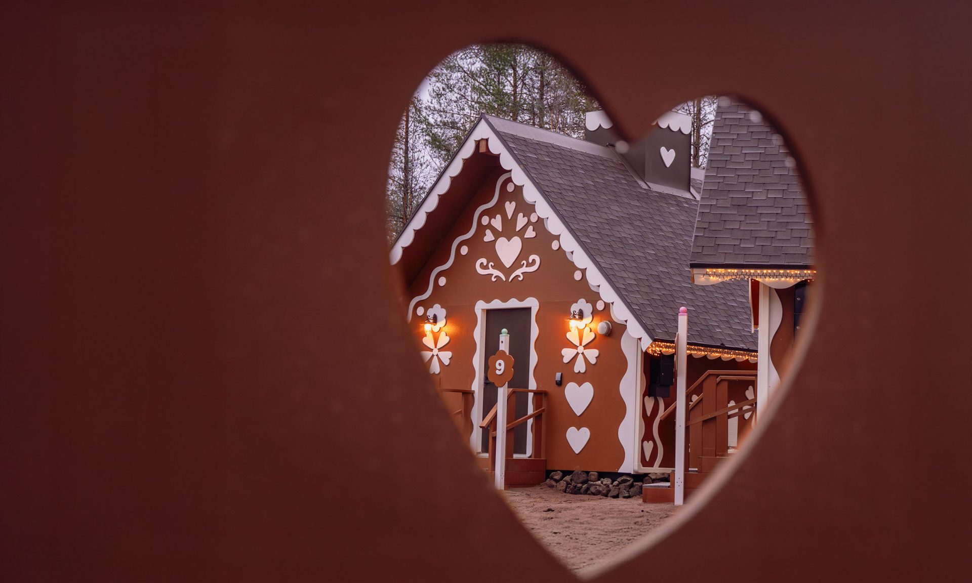 Piparitalo nähtynä sydämen muotoisesta aukosta Joulupukin pajakylässä.