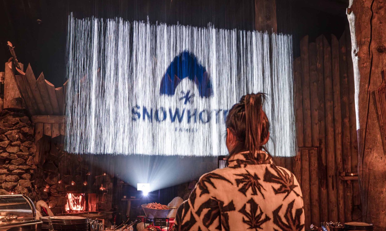 A waterfall screen at Piparina restaurant with the Snowhotel Family logo projected onto it.