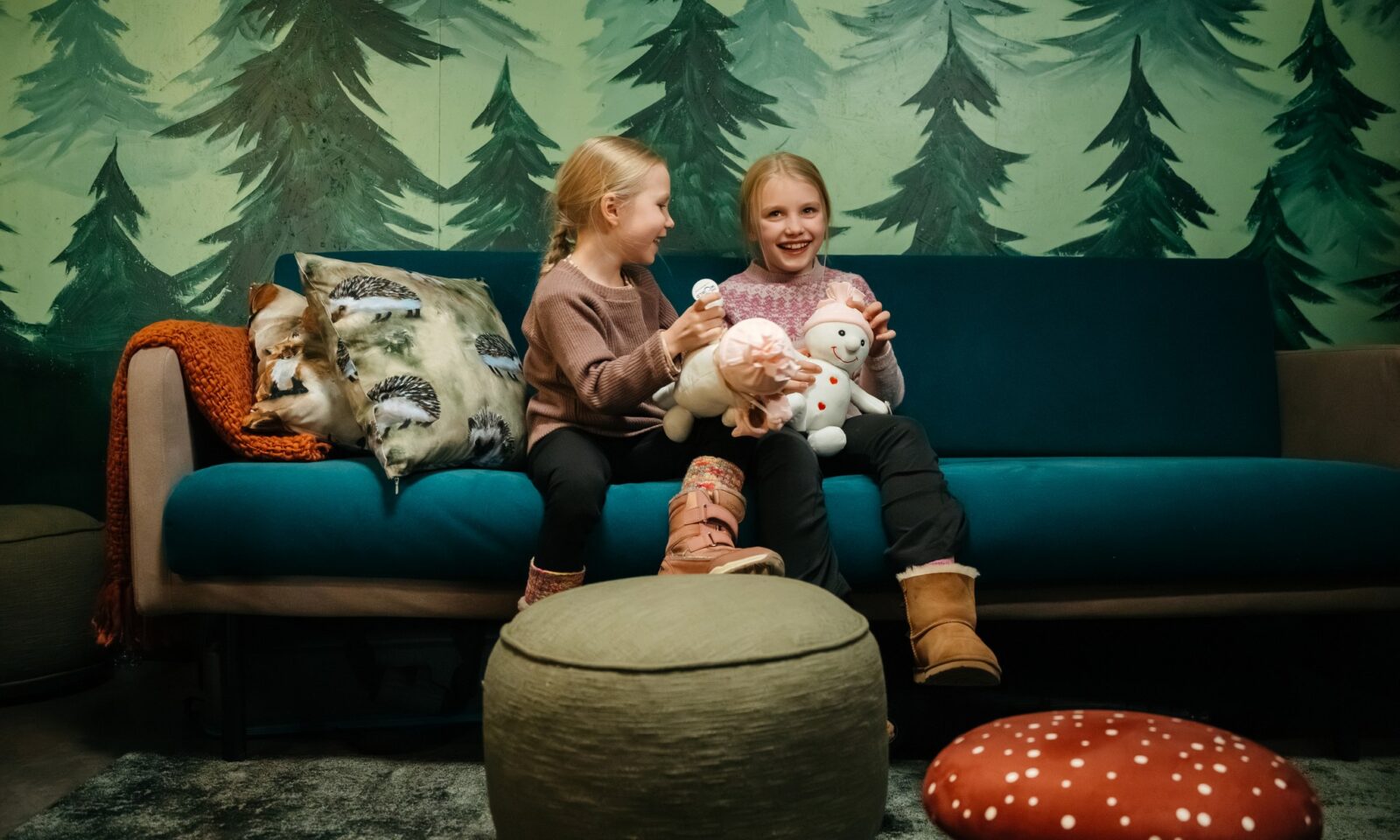 Two children playing with toys on the sofa.