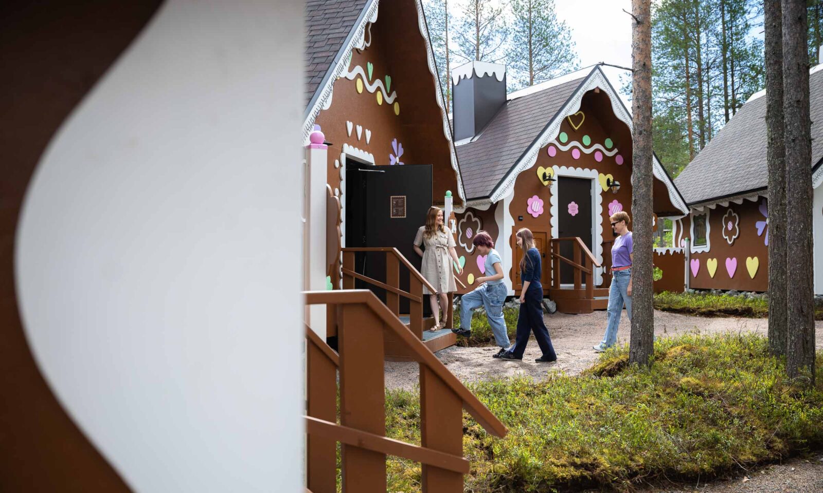 A group of friends entering a gingerbread cabin at Piparina in Santa Claus Village, Rovaniemi.